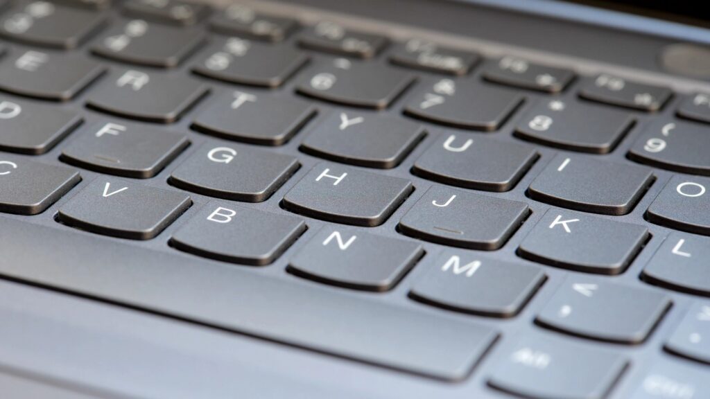 Simple new clean silver grey modern laptop keyboard, nobody, wide shot, shallow DOF, no people, angle. Creative content writing online freelance jobs symbol, abstract concept, blogging, SEO articles